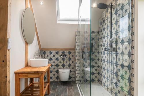 Un baño con lavabo y ducha de cristal. en The Long Barn, en Oxford