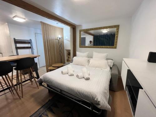 Un dormitorio con una cama con un espejo y una mesa. en Paris Expo Ranko, en Vanves