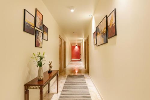 a hallway with a table and paintings on the walls at FabHotel Nestlay Rooms High Court - Nr Parry's Corner in Chennai