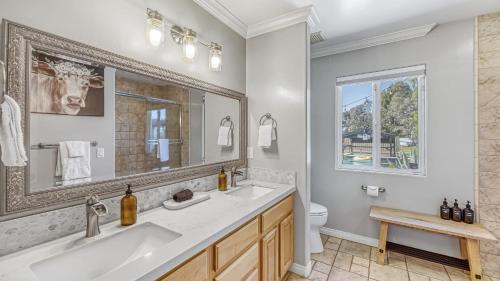 a bathroom with a sink and a mirror and a toilet at Temecula Wine Country Home w Pool Hot Tub Game Room Vineyard Views in Country Road Estates