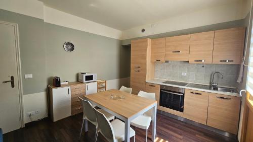 a small kitchen with a wooden table and chairs at Residenza Alle Fonti palazzo del 1886 nel cuore di Vittorio Veneto in Vittorio Veneto