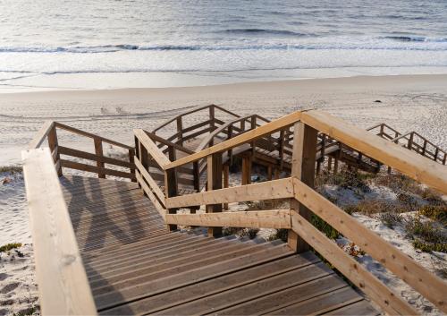 a wooden staircase leading down to the beach at Shellter Apartments by the sea in Vieira de Leiria