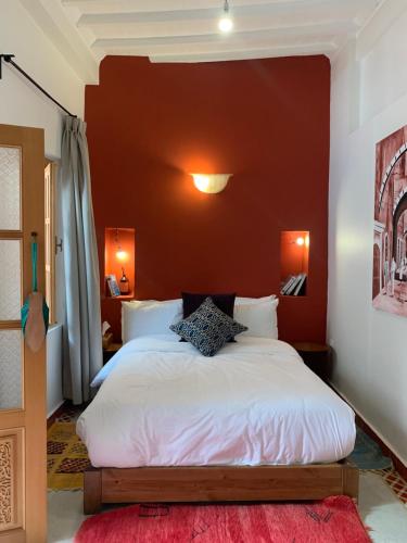 索维拉Riad Mazal Mogador的卧室配有白色的床铺和红色的墙壁