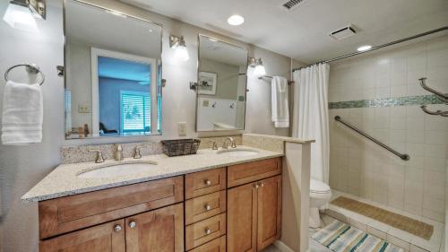 a bathroom with two sinks and a shower at Sleeps 16 2 Beachfront Condos PoolPickleballTennis Island Retreat Complex in Port Aransas