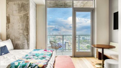 ein Schlafzimmer mit einem Bett und einem großen Fenster in der Unterkunft Sleeps 40 12 Condos in New Austin High Rise w Rooftop Pool Gym Yoga Studio in Austin