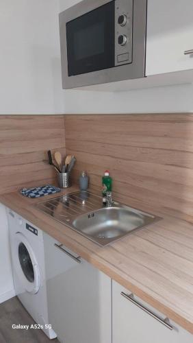 a kitchen with a sink and a microwave at SER5 studio avec WIFI et Parking à Saint-Etienne-Du-Rouvray in Saint-Étienne-du-Rouvray