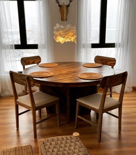 a dining room table with chairs and a wooden table at Casa Montaña de Riaño y Picos de Europa I in Riaño