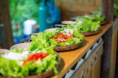 a row of bowls of salad on a table at Chez Vous House - Toom Sara in Mang Son