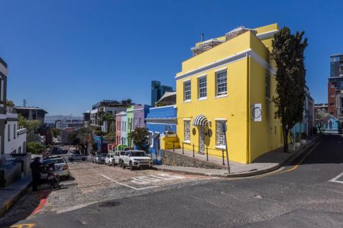 a yellow building on the side of a street at De Waterkant Place in Cape Town