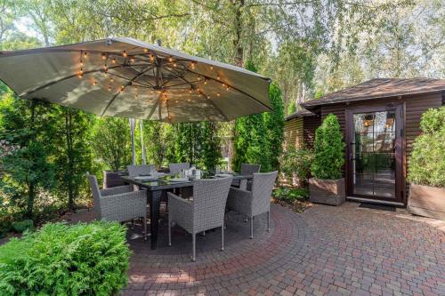 a patio with a table and chairs and an umbrella at SPA Hotel Galera in Kyiv