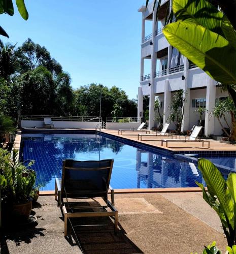 a hotel swimming pool with a chair next to a building at Lanta Sport Resort in Ko Lanta