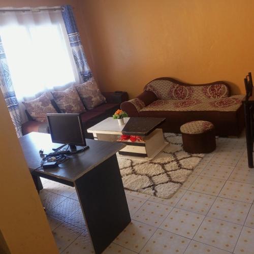 a living room with a couch and a desk with a computer at Brilliant homes in Mombasa