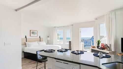 a hotel room with a bed and a kitchen with a desk at 4 Cayucos Bungalows Steps to Beach Sleeps 16 Pet Friendly in Cayucos