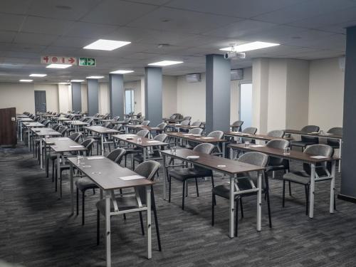 una classe vuota con scrivanie e sedie all'interno di ANEW Hotel Centurion Pretoria a Centurion