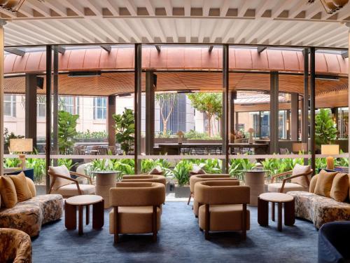a lobby with couches and tables and windows at Sofitel Sydney Wentworth in Sydney