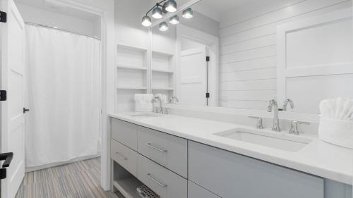 アイル・オブ・パームズにある712 Ocean Blvd by AvantStay Luxe Beach House w Pool Game Zone Beach Access and Viewsの白いバスルーム(シンク2台、鏡付)