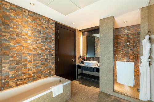 a bathroom with a bath tub and a sink at The K Hotel in Manama