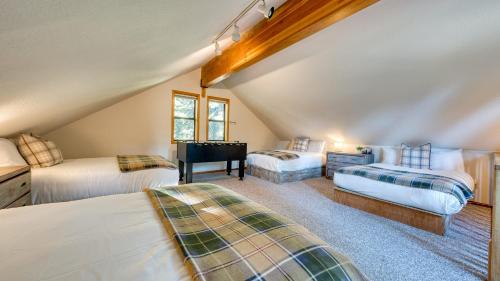a attic bedroom with two beds and a piano at Cozy Escape w Hot Tub Deck & Access to Tahoe Donner & Skiing Alpenglow Chalet by AvantStay in Truckee