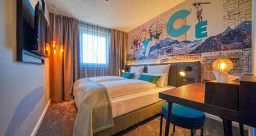a hotel room with a bed and a desk at PLAZA INN Ulm in Ulm