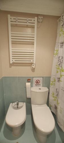 ein Badezimmer mit weißer Toilette und Waschbecken in der Unterkunft Naturaleza y Golf in San Jorge