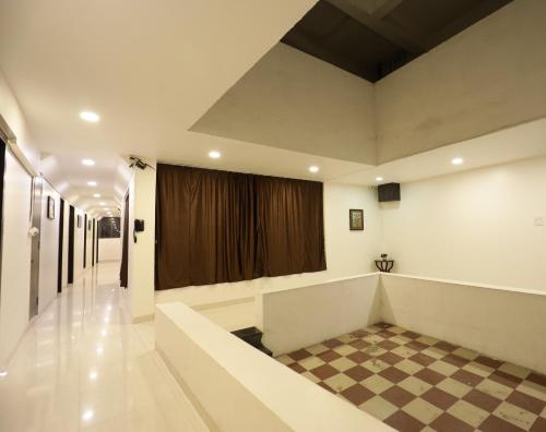 a meeting room with a stage and a checkered floor at Hotel The White House in Ahmadnagar