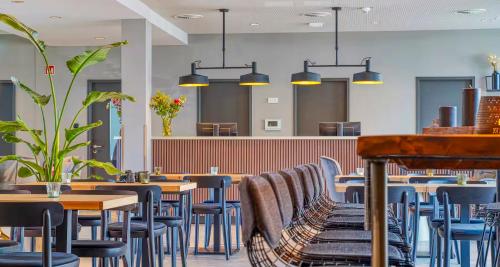 a restaurant with wooden tables and blue chairs at PLAZA INN Ulm in Ulm