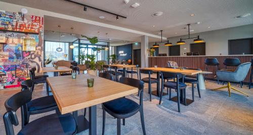 a restaurant with wooden tables and chairs at PLAZA INN Ulm in Ulm