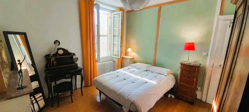 a bedroom with a bed and a dresser and a piano at Maison 7 pers coeur de chtx cour wifi in Châteauroux