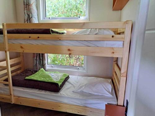 ein paar Etagenbetten in einem Zimmer mit Fenster in der Unterkunft Camping les Pialades -Chalet Mimosa in La Mouline