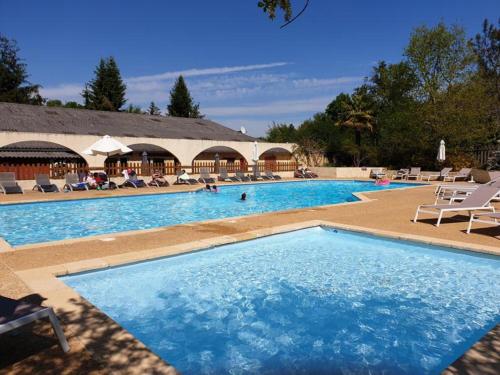 ein großer Pool mit Stühlen und Menschen darin in der Unterkunft Camping les Pialades -Chalet Mimosa in La Mouline