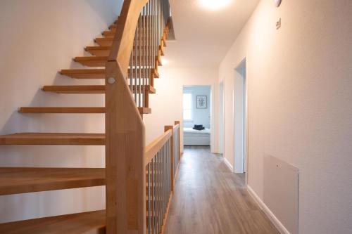 a wooden staircase in a home with white walls and wooden floors at Michelhuus 3 St Michaelisdonn in Westdorf