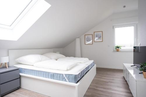 a white bedroom with a bed and a window at Michelhuus 3 St Michaelisdonn in Westdorf