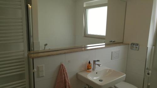 a white bathroom with a sink and a mirror at Zimmervermietung im Zentrum Waiblingens in Waiblingen