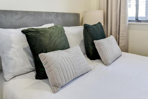 ein weißes Bett mit vier Kissen darauf in der Unterkunft Knighton Chambers, Bognor Regis - Brand new studio in Bersted