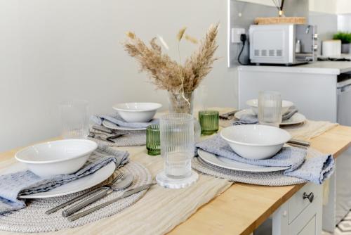 ein Tisch mit Tellern und Schüsseln auf einer Küchentheke in der Unterkunft Knighton Chambers, Bognor Regis - Brand new studio in Bersted