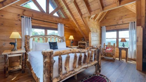 ein Schlafzimmer mit einem Bett in einer Blockhütte in der Unterkunft Big Bear Lodge by AvantStay Smoky Mountain Views Hot Tub Theater Game Room in Sevierville