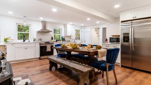 a kitchen with a wooden table and a refrigerator at Pondfront Gem Minutes from Hudson’s Best Shops Cafes The Stillwater House in Hudson