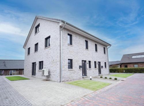 a large white brick building with black windows at Michelhuus 2 St Michaelisdonn in Westdorf