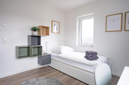 a white room with a bed and a window at Michelhuus 2 St Michaelisdonn in Westdorf