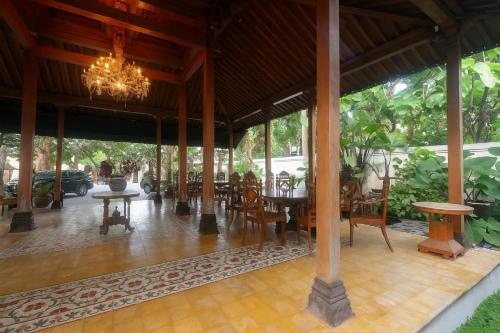 a restaurant with a chandelier and tables and chairs at The Mangkoro Hotel by Sinergi in Yogyakarta
