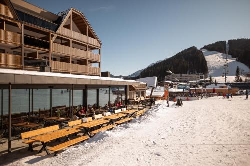 a group of benches on a beach next to a building at ADEA Lifestyle Suites Fieberbrunn in Fieberbrunn