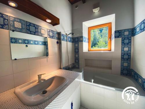a bathroom with a sink and a tub and a mirror at Le Moulin du Go in Tauriac-de-Naucelle