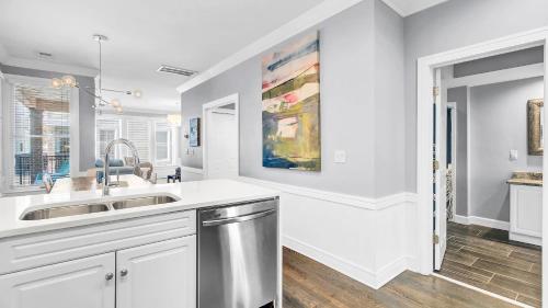 a white kitchen with a sink and a window at 125 Grand Pavillion by AvantStay Steps from Sand in Isle of Palms