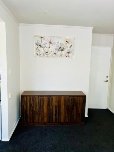 ウェリントンにあるSunny private room with private bathroomの木製ドレッサー付きの部屋