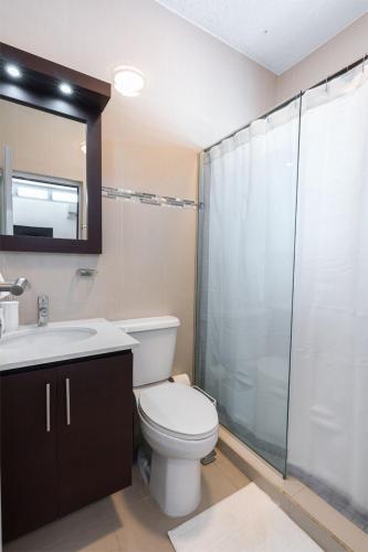 a bathroom with a toilet and a sink and a shower at Aquaville Dorado Moderna Villa 4 in Dorado