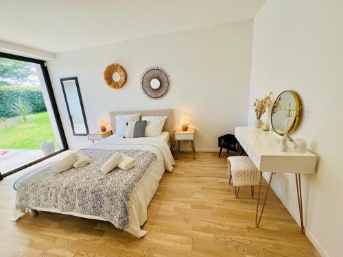 a bedroom with a bed and a desk and a mirror at Exceptional villa in Combrit - in Combrit