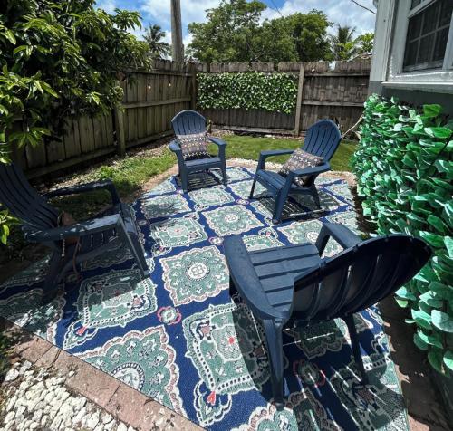 un patio con tre sedie e un tavolo su un tappeto di 2918 Madison St HOLLYWOOD a Pembroke Park