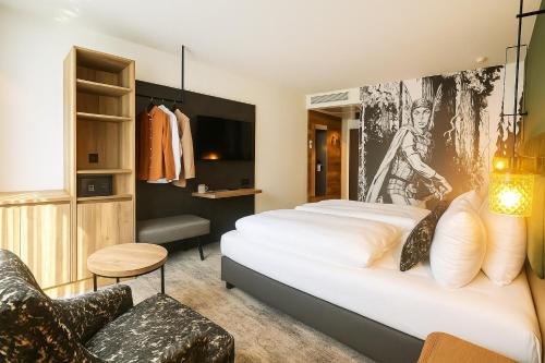 a hotel room with a bed and a chair at Dom-Hotel in Worms