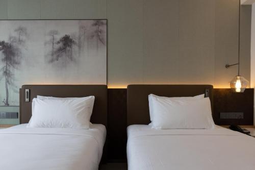 two beds sitting next to each other in a room at Laike Hotel in Bangkok