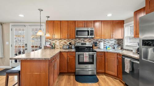 a kitchen with wooden cabinets and stainless steel appliances at Poconos Getaway w Firepit Lake Access Near Jack Frost Big Boulder Ski in Pocono Lake